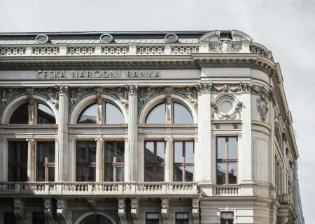 Economia României Sub Lupă: Previziunile Analiștilor CFA Arată o Decelerare Dramatica în 2025 Elegant exterior of Česká Národní Banka showcasing classic architecture in Prague, Czech Republic.