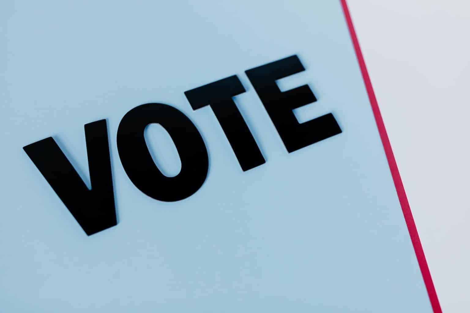 Alegerile din România: Candidatul favorit, Călin Georgescu, promite să pună capăt ajutoarelor către Ucraina Close-up of the word 'VOTE' on a minimal background, emphasizing voting importance.